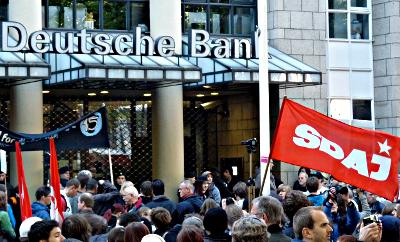 Demonstranten mit SDAJ-Fahne vor der Deutschen Bank.