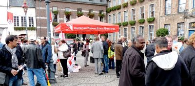 Zamek-Kolleginnen und -Kollegen vor dem Rathaus, dabei NGG mit Trans­pa­renten, Fahnen, Laut­sprecher und Schirm.
