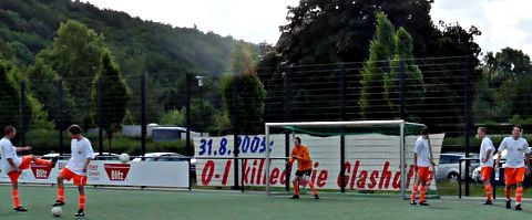Fußballspiel. Hinter dem Tor am Zaun riesiges Transparent: »31.8.2005: O-I killed die Glashütte«.
