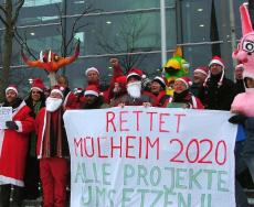 Köln: Weihnachtsfrauen und -männer demonstrieren vor dem Bezirksrathaus am Wiener Platz. Transparent: Rettet Mülheim 2020. Alle Projekte umsetzen!