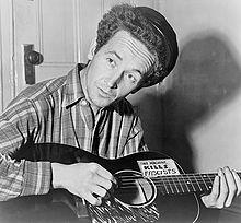 Woody Guthrie mit Gitarre.