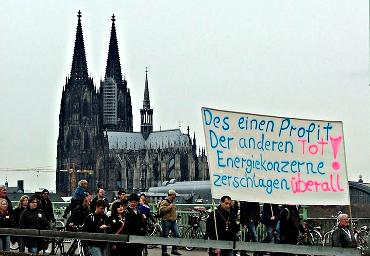 Köln, im Hintergrund der Dom. Demonstranten mit Transparent: »Des einen Profit. Der anderen Tot. Energiekonzerne zerschlagen. Überall!«