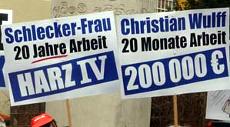 Zwei Transparente: »Schlecker-Frau 20 Jahre Arbeit: Harz IV« und »Christian Wulff 20 Monate Arbeit: 200 000 Euro«.
